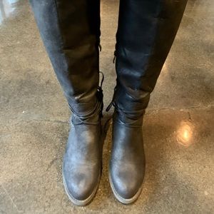 Women’s knee high black boots with laces.
